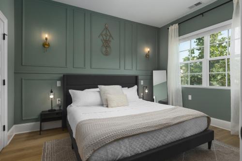ein Schlafzimmer mit einem großen Bett mit grünen Wänden in der Unterkunft Trendy Spacious Condo, Walk to Coffee and Restaurants in Nashville
