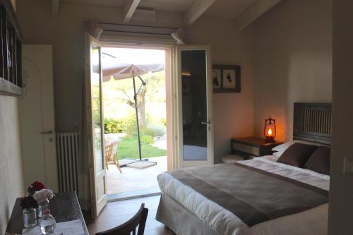 ein Schlafzimmer mit einem Bett und eine Terrasse mit einem Sonnenschirm in der Unterkunft B&B Kapì Country in Alghero