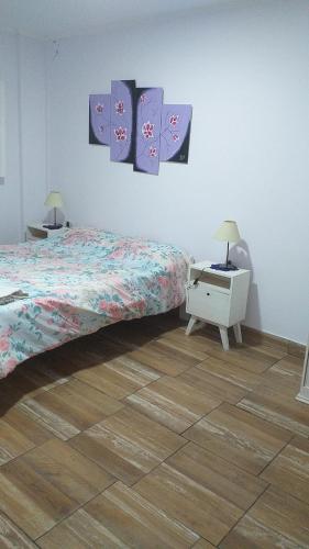 een slaapkamer met een bed en twee schilderijen aan de muur bij quinta martin schneider in Junín