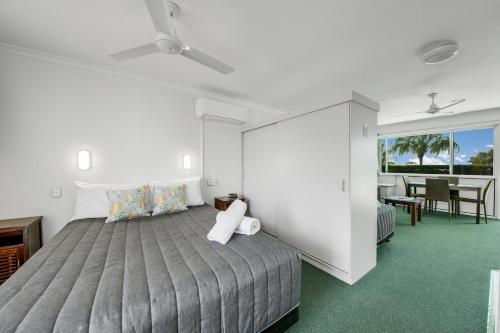 een slaapkamer met een groot bed en een eetkamer bij Reef Adventureland Motor Inn in Tannum Sands
