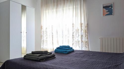 een slaapkamer met een bed met blauwe handdoeken bij Appartamento La Terrazza in Trapani