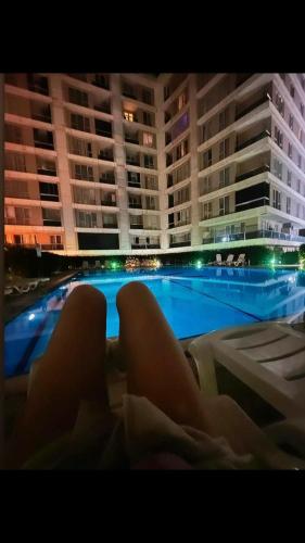 a woman laying on a bed in front of a swimming pool at CAN SUIT in Çekmeköy