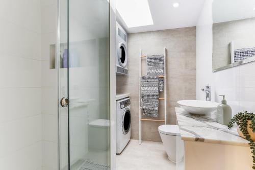 a bathroom with a sink and a washing machine at Surry Hills l 2 Bedroom Terrace Home in Sydney