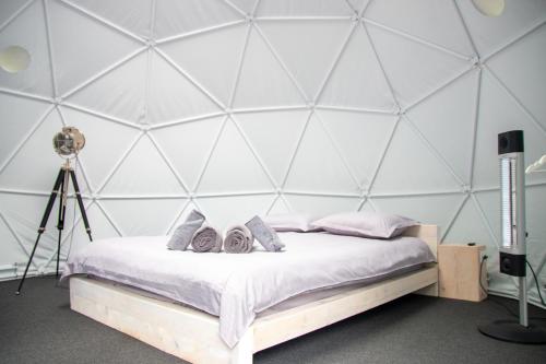 a bedroom with a bed with two pairs of shoes on it at The Grand Prestige Igloo in Gura Teghii