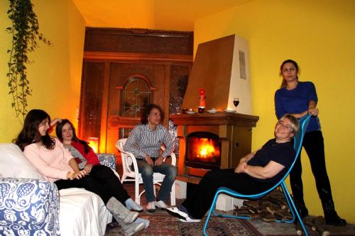 a group of women sitting in chairs in a room with a fireplace at Europa Pension Tirol in Fliess