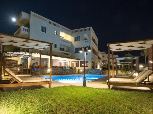 a villa with a swimming pool at night at Aphrodite Beach in Kissamos