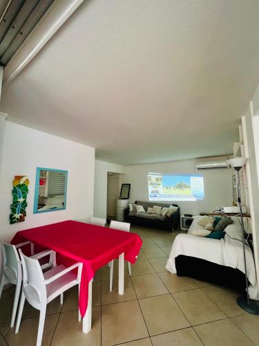 - un salon avec une table rouge et un canapé dans l'établissement Chambre d'Hôtes Coconut Marina du Gosier, au Gosier