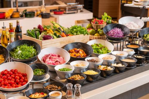 a buffet with bowls of different types of vegetables at Art Hotel Narita in Narita