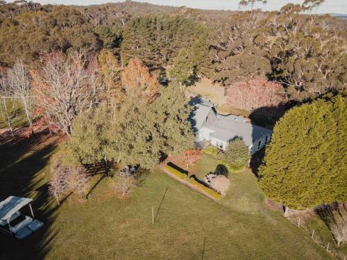 an overhead view of a house in a field with trees at The Maple Lodge with Alpacas, Goats, Boars, Ducks & Chickens Farm Stay with Outdoor Pizza Oven in Robertson