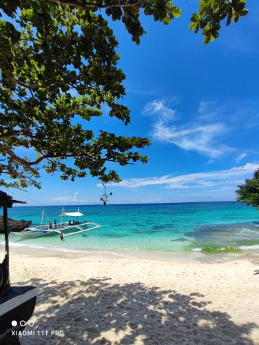 a boat on a beach in the ocean at Rose Apartments in Anda