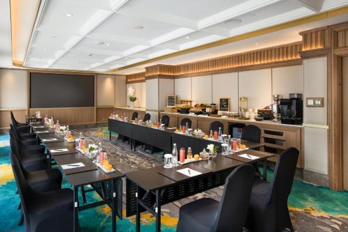 a conference room with long tables and chairs at Royal Ambarrukmo Yogyakarta in Yogyakarta