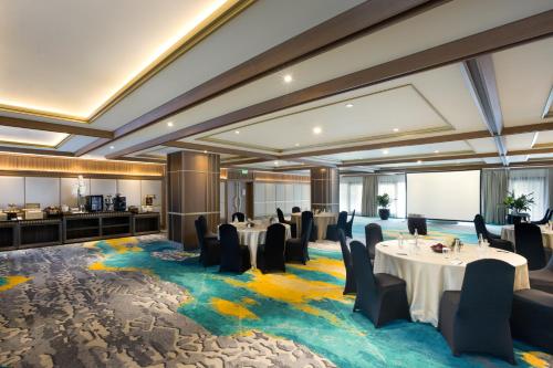 a dining room with tables and chairs on a colorful carpet at Royal Ambarrukmo Yogyakarta in Yogyakarta