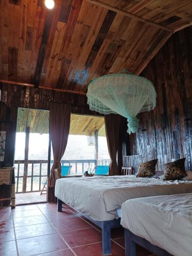 a bedroom with two beds in a room with wooden ceilings at Mu Cang Chai Eco Lodge in Nam San