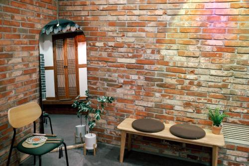a brick wall with a table and chairs in front of it at Starria Hostel foreign guest only in Seoul