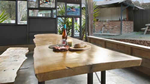 a wooden table with a plate of food on it at Mingling Waters in Nowa Nowa