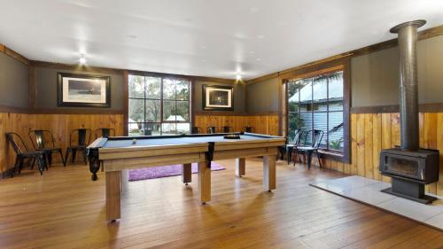 a room with a pool table and a fireplace at Mingling Waters in Nowa Nowa
