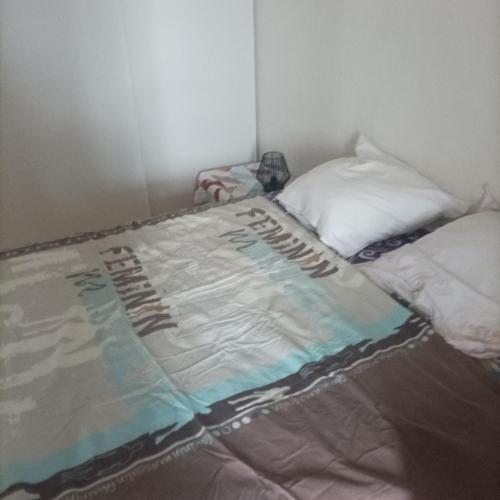 Una cama con una manta en una habitación en CHAMBRE PRIVEE AVEC VUE SUR LA RHUNE, en Urrugne