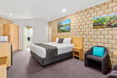 a hotel room with a bed and a chair at Great Divide Motor Inn in Toowoomba