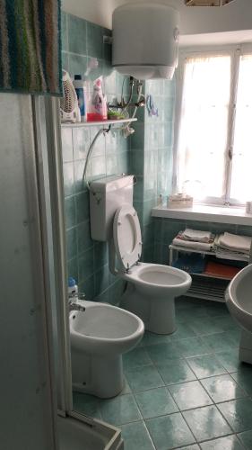 a bathroom with a toilet and a sink at JOLIE PETITE MAISON chez Barbara in Garbagna