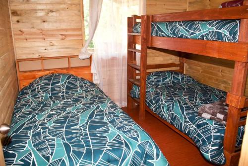 El TorreónにあるCabañas oasis, radal 7 tazasのキャビン内のベッドルーム1室(二段ベッド2組付)