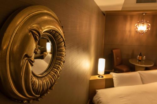 a gold mirror in a hotel room with a bed at Urayasu Brighton Hotel Tokyo Bay in Urayasu