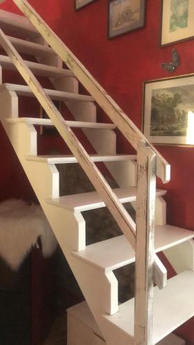 a staircase in a house with a red wall at JOLIE PETITE MAISON chez Barbara in Garbagna