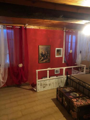 a room with red walls and red curtains at JOLIE PETITE MAISON chez Barbara in Garbagna