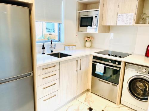 a kitchen with a sink and a dishwasher at Perfect modern Townhouse CBD Christchurch in Christchurch