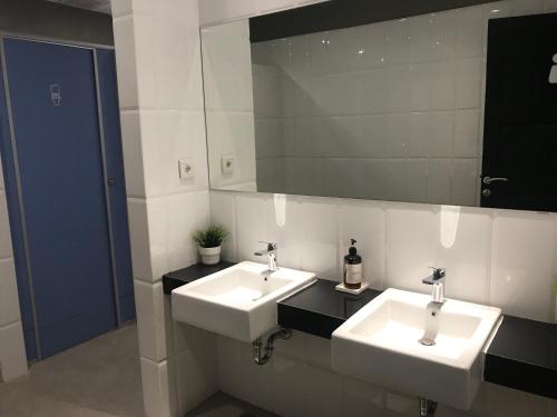 La salle de bains est pourvue de 2 lavabos et d'un miroir. dans l'établissement PassGo Thamrin, à Jakarta