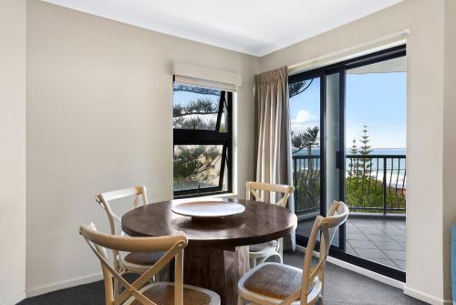 a dining room with a table and chairs and a balcony at Gena Apartments Unit 13 Kings Beach QLD in Caloundra