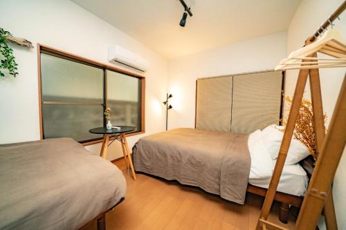 1 dormitorio con 2 camas y ventana en Kawanoso - Vacation STAY 8104, en Tokio