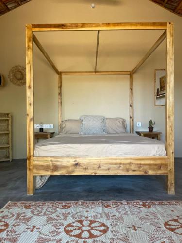 a bed with a wooden frame in a room at Gypsea Cabana in Arugam Bay