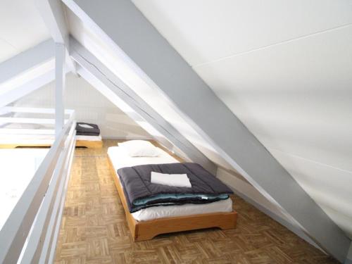 a bedroom with a bed in the middle of a attic at Gîte Arnac, 2 pièces, 4 personnes - FR-1-742-298 