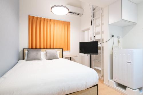 Schlafzimmer mit einem weißen Bett und einem TV in der Unterkunft AZEST-RENT Haneda 11 in Tokio