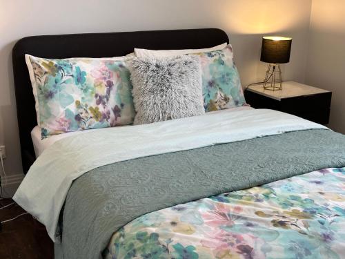 a bed with a floral bedspread and pillows on it at Daisy Cottage on Duke 3BR in Yarram