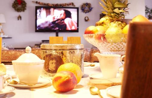 a table with fruit and a tv in a room at B&B Le Tre Grazie in San Martino di Lupari