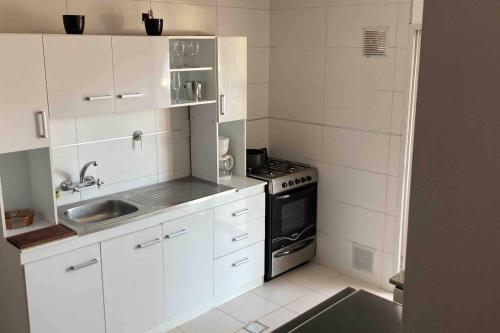 a white kitchen with a stove and a sink at NEW!Departamento x 4 pesonas. in Malargüe