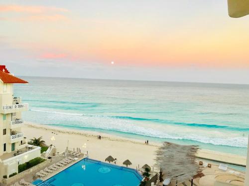 a view of the beach from the balcony of a resort at OVA Apartments Cancun in Cancún