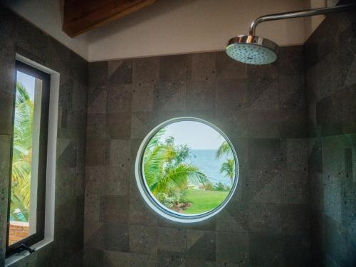 a round window in a bathroom with a view of the ocean at Casa de la Luna in Puerto Escondido