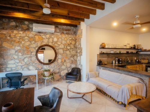 a living room with a couch and a stone wall at Casa de la Luna in Puerto Escondido