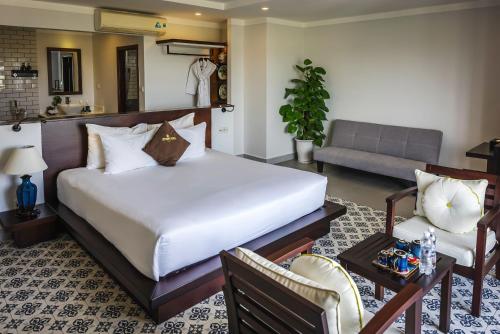 ein Schlafzimmer mit einem Bett und ein Wohnzimmer in der Unterkunft Hoi An Odyssey Hotel & Spa in Hoi An