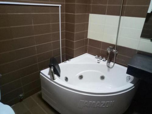 a bath tub in a bathroom with a shower at Holiday Hotel in Hai Phong