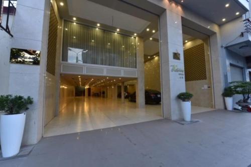 a large building with a lobby with potted plants at Holiday Hotel in Hai Phong