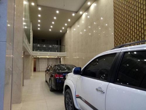 two cars parked in a parking lot in a building at Holiday Hotel in Hai Phong