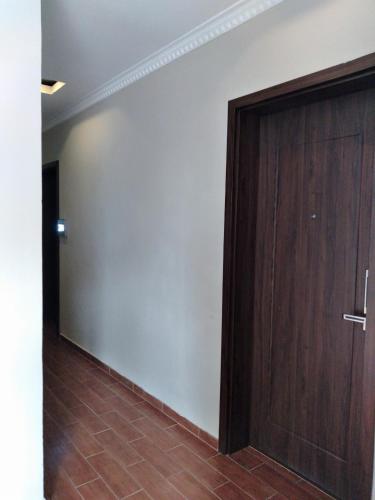 a room with a wooden door and a wall at Holiday Hotel in Hai Phong