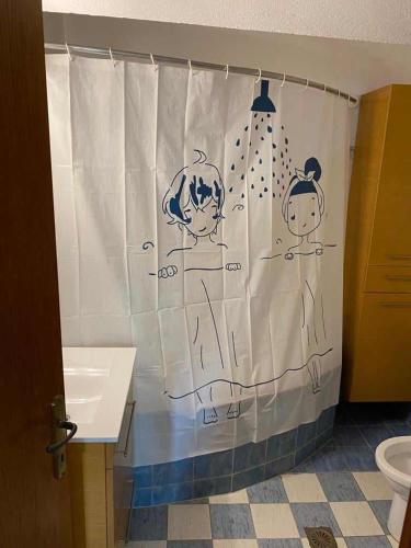 a bathroom with a shower curtain with drawings on it at Dellmar Apartment in Perea