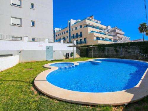 a swimming pool in a yard next to a building at Apartamento con terraza y acceso directo a piscina in Denia