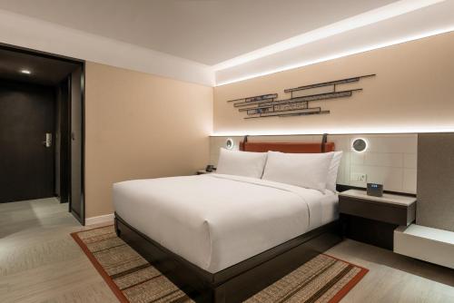 a bedroom with a large white bed with white pillows at DoubleTree by Hilton Bangkok Ploenchit in Bangkok