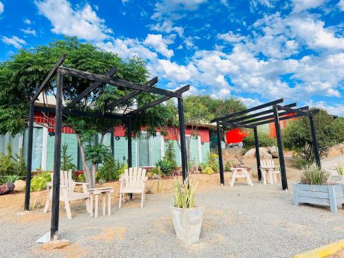 a pergola and chairs in front of a house at Rancho Matalote en Valle de Guadalupe in Valle de Guadalupe