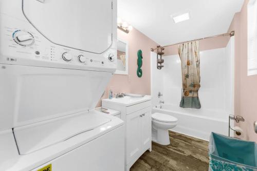 a bathroom with a sink and a toilet and a mirror at Beautiful Centrally Located Beach House w King Bed, Private Hot tub, Yard, Deck & BBQ in Myrtle Beach